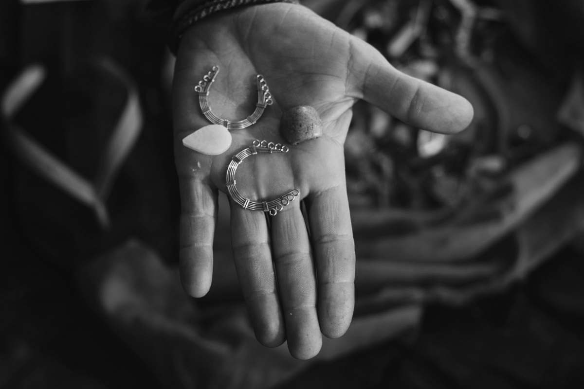 person person holding silver-colored earrings black-and-white
