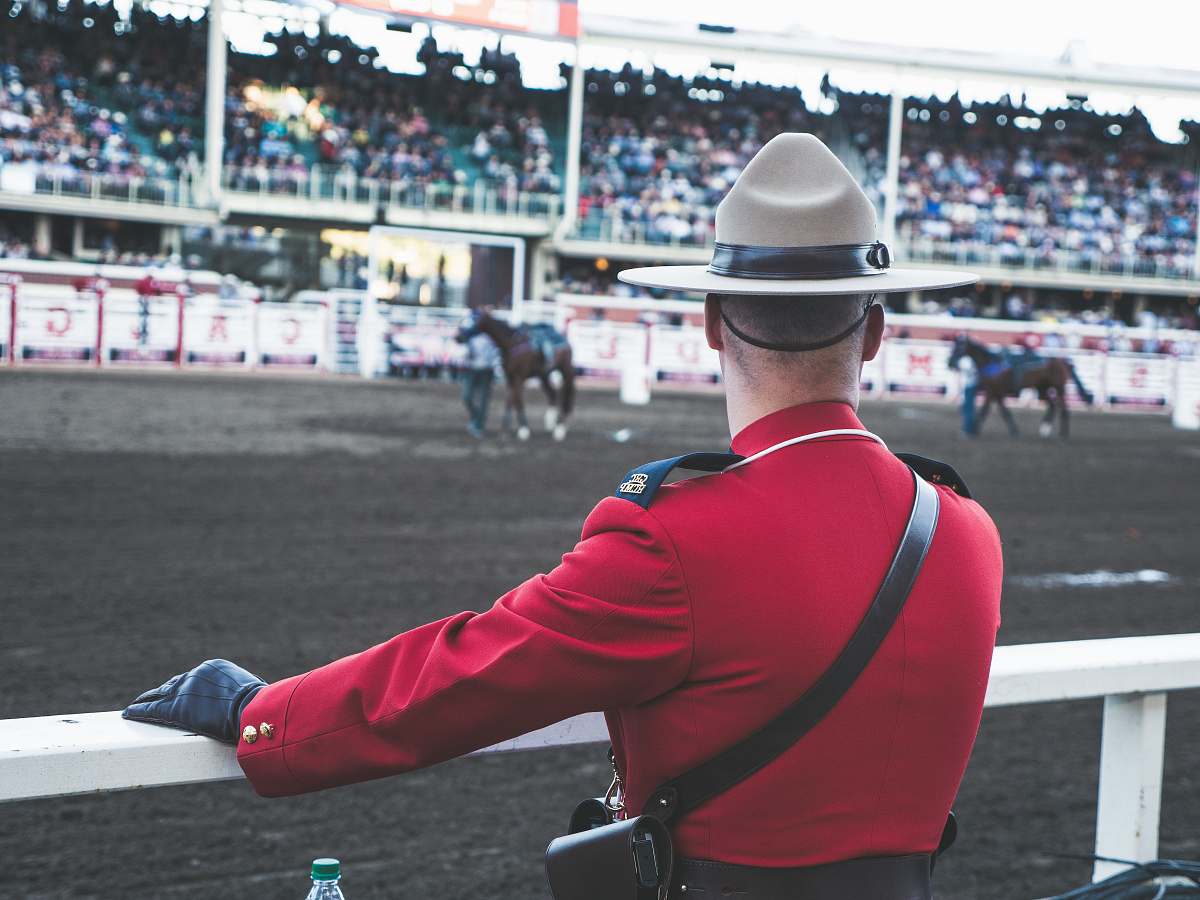 human person in red coat watching horse racing person