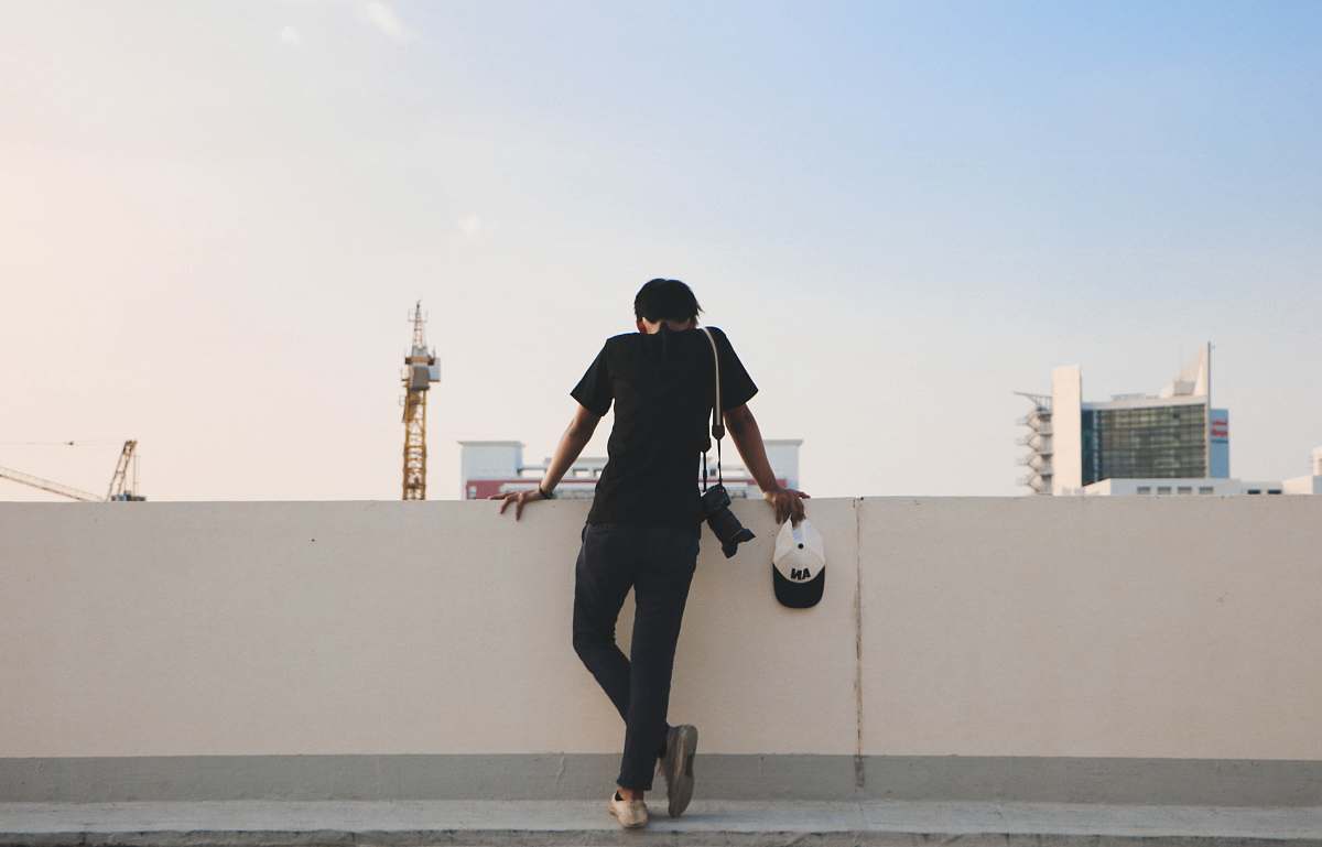 human person leaning against white wall person
