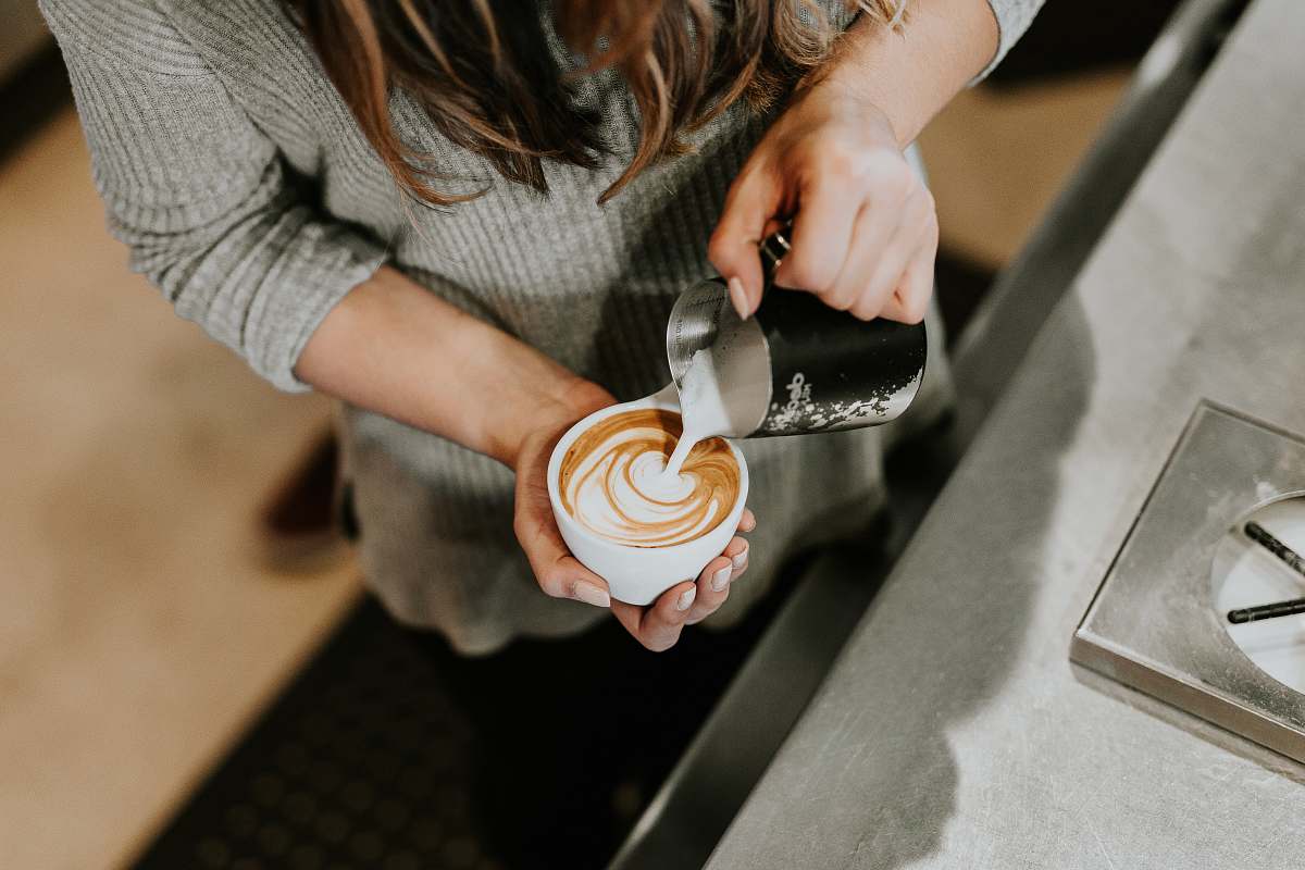 person person pouring cup of coffee in white ceramic cup human