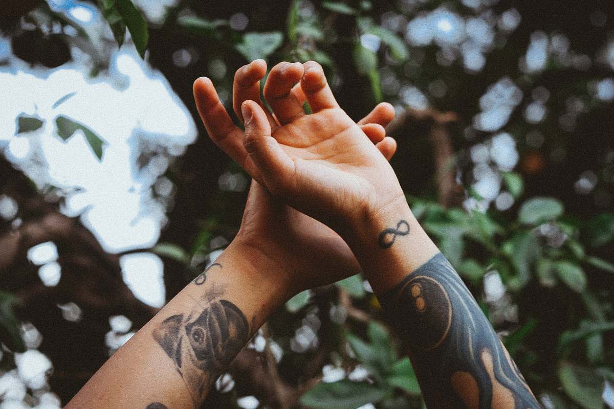 tattoo person raising his hands near tree hands