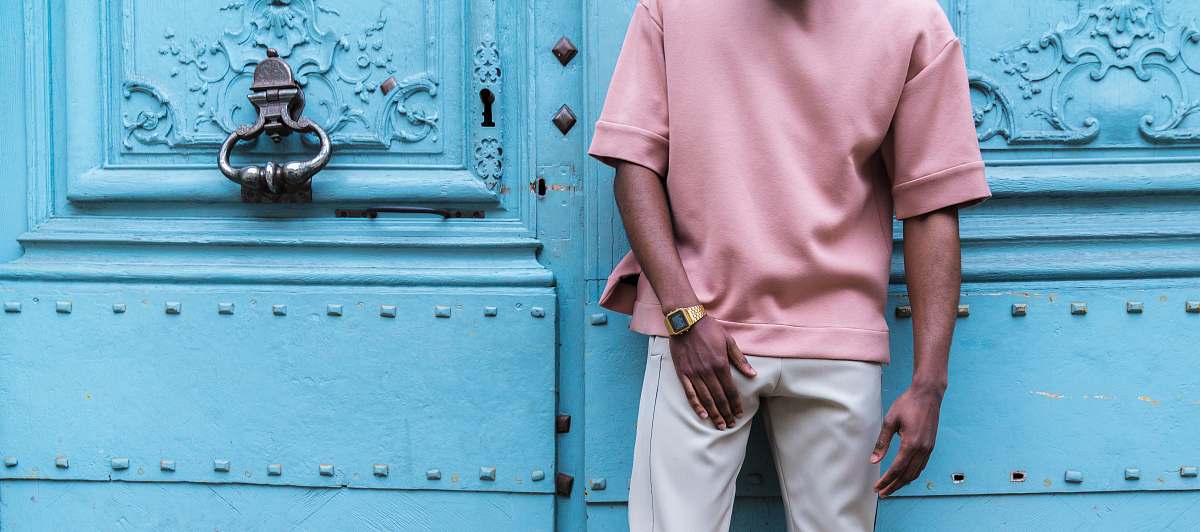 human person standing beside blue painted wall person