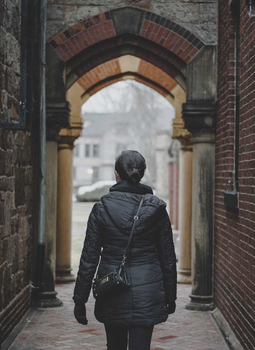 human person standing on alleyway during daytime person