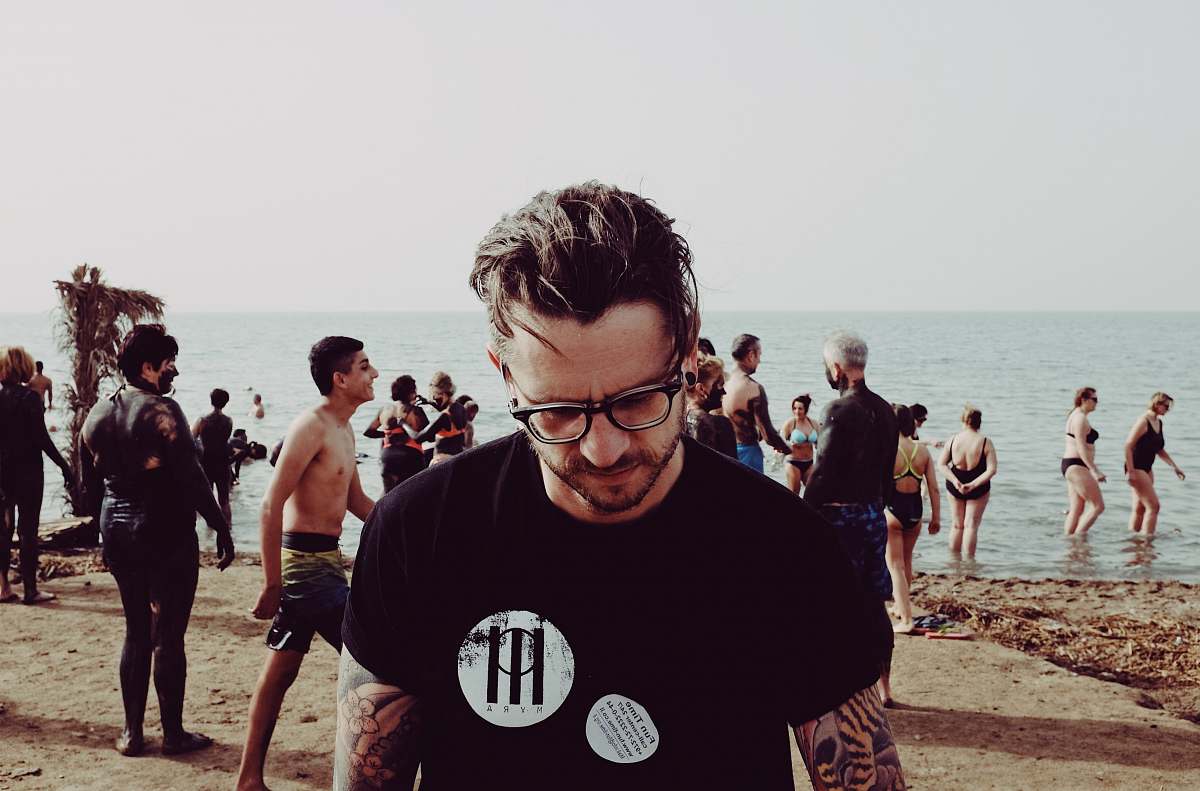 human photo of man wearing eyeglasses standing on beach during daytime person