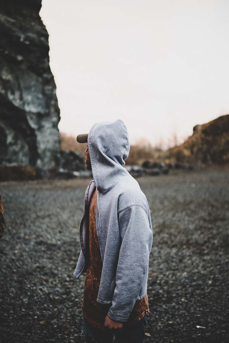 human selective focus photography of man standing near rock formation person