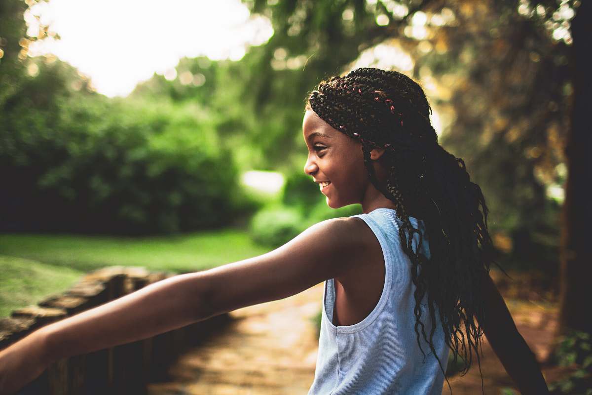 person shallow focus photography of girl in white tank top near tree during daytime human
