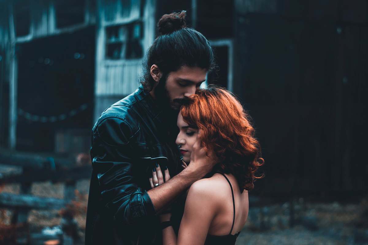 human shallow focus photography of man and woman hugging person