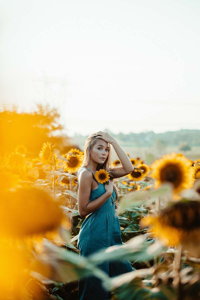 human shallow focus photography of woman holding yellow sunflower person