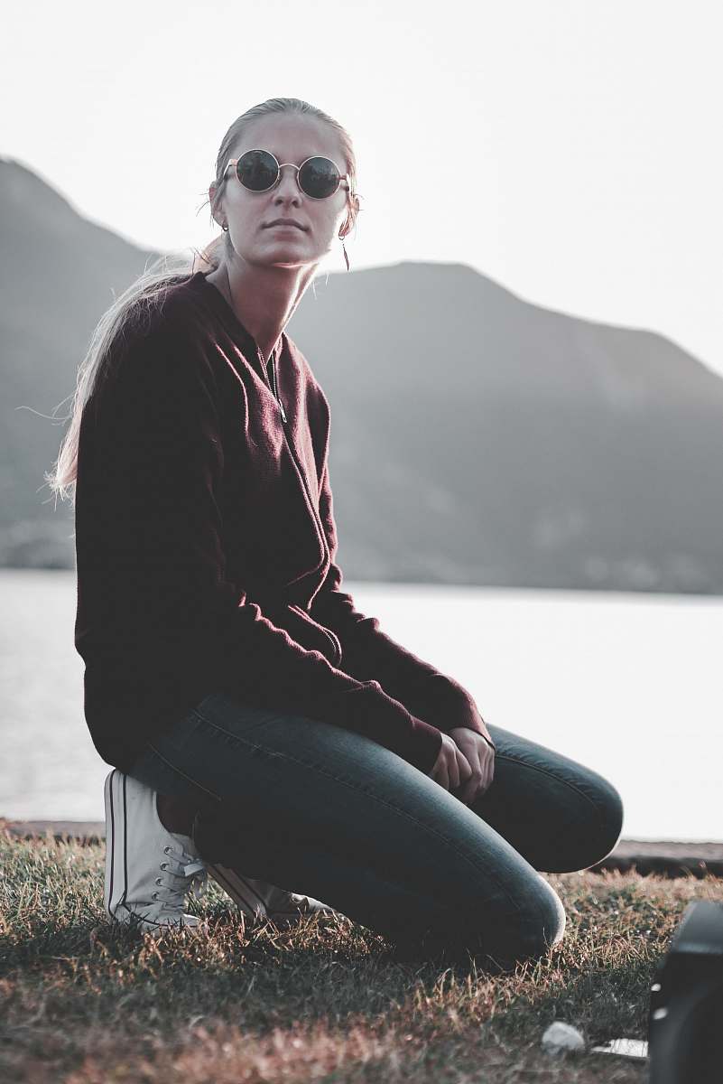 person shallow focus photography of woman kneeling at the grass looking side ways human