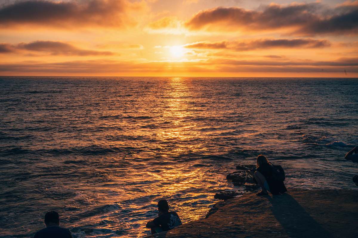 human silhouette of men in body of water during sunset person