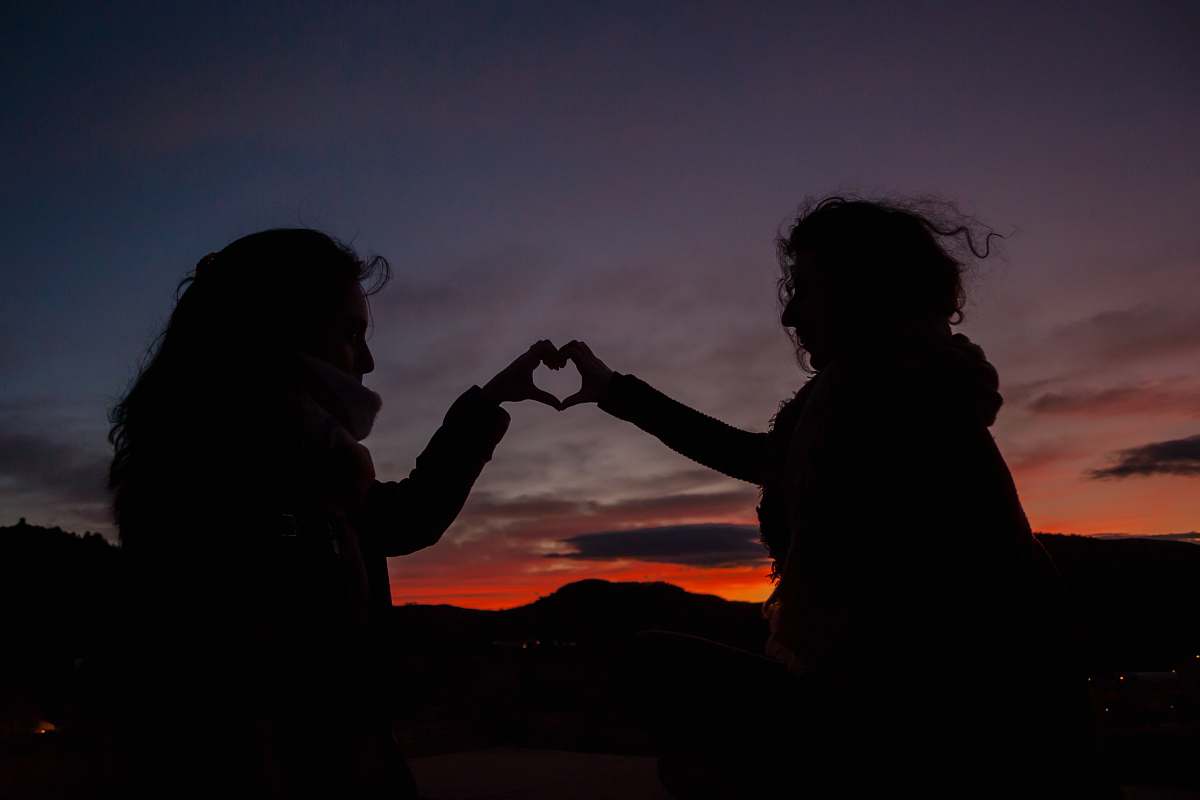 human silhouette of persons doing heart hand person