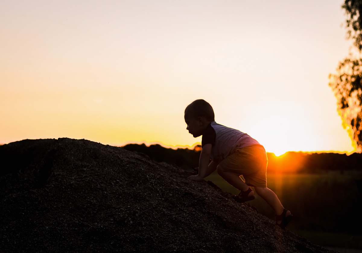 human silhouette photography of child climbing on rock person
