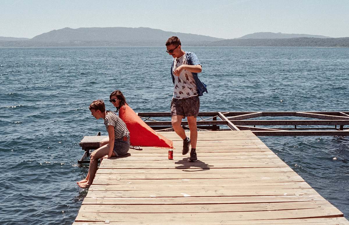 person three person standing on dock pier