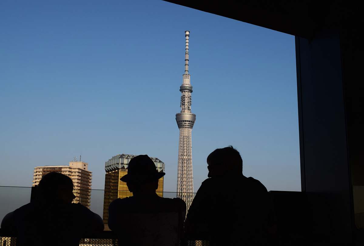 person three silhouette of persons standing in front window watching tower building human