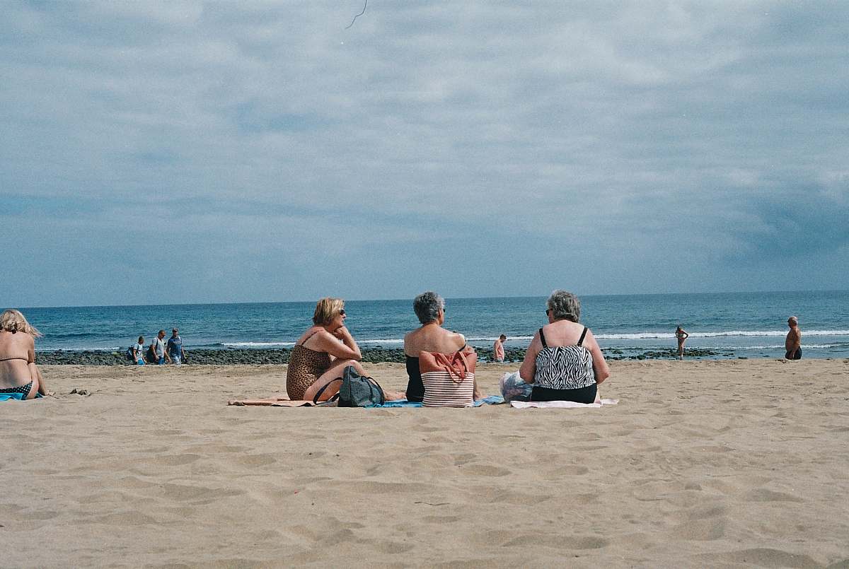 beach three women sitting on beach sea