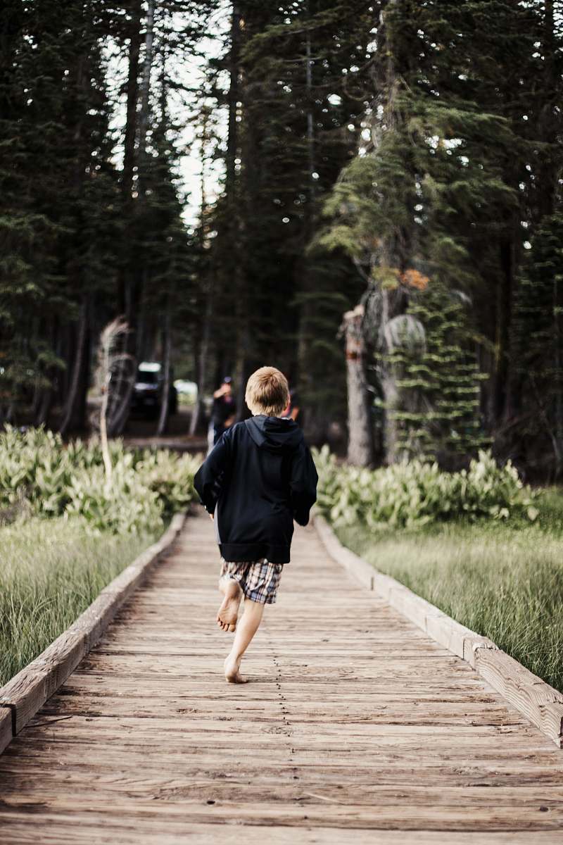 person toddler running on brown wooden pathway human