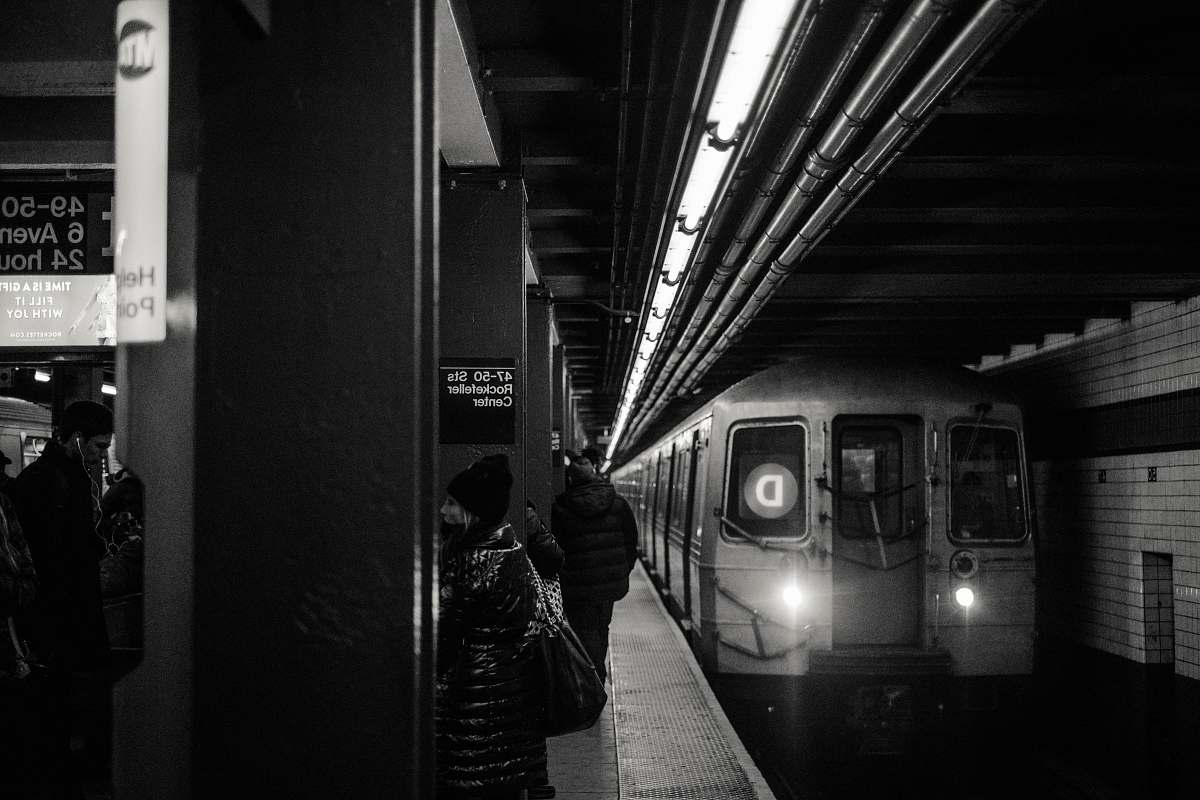 black-and-white train passing in train station grayscale photography subway