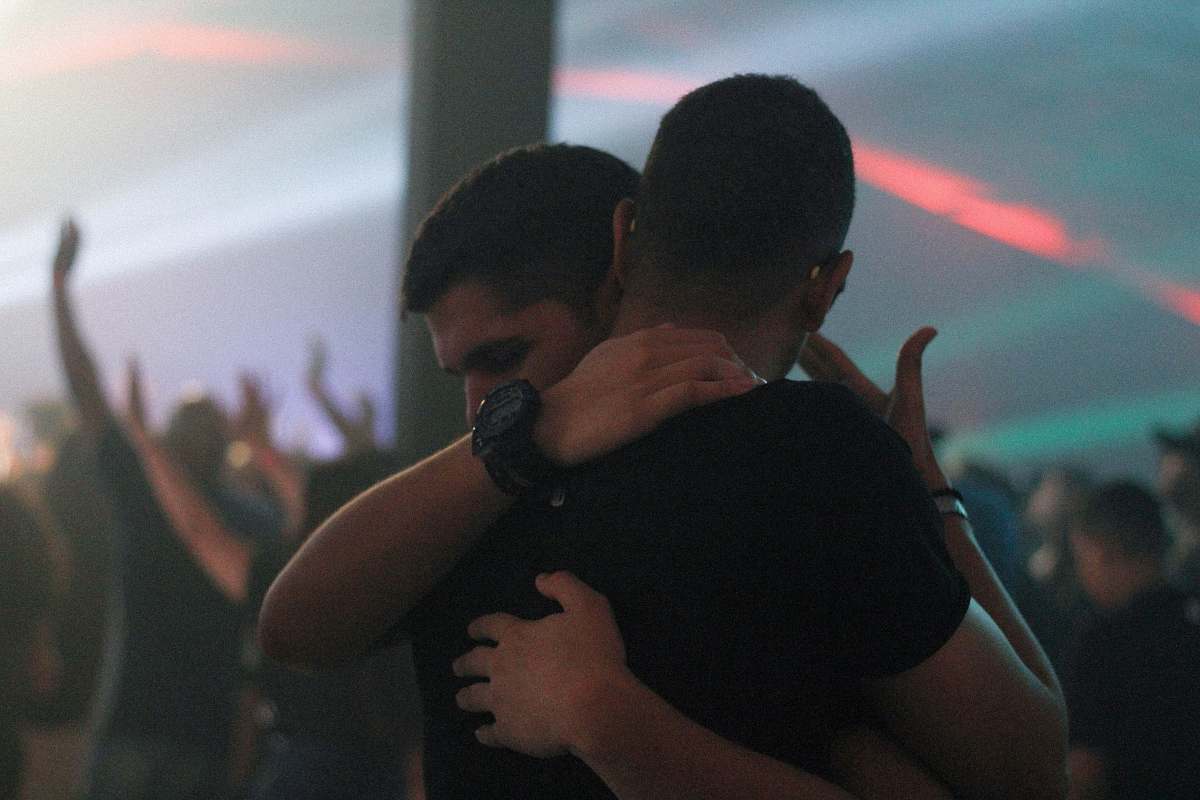 human two men hugging each other inside bar person