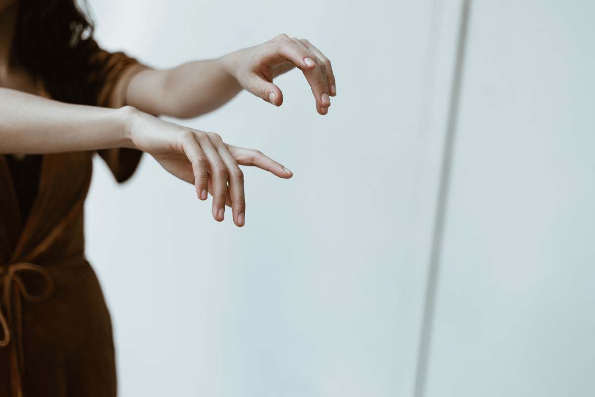 person two person standing while raising hands inside white painted room hands