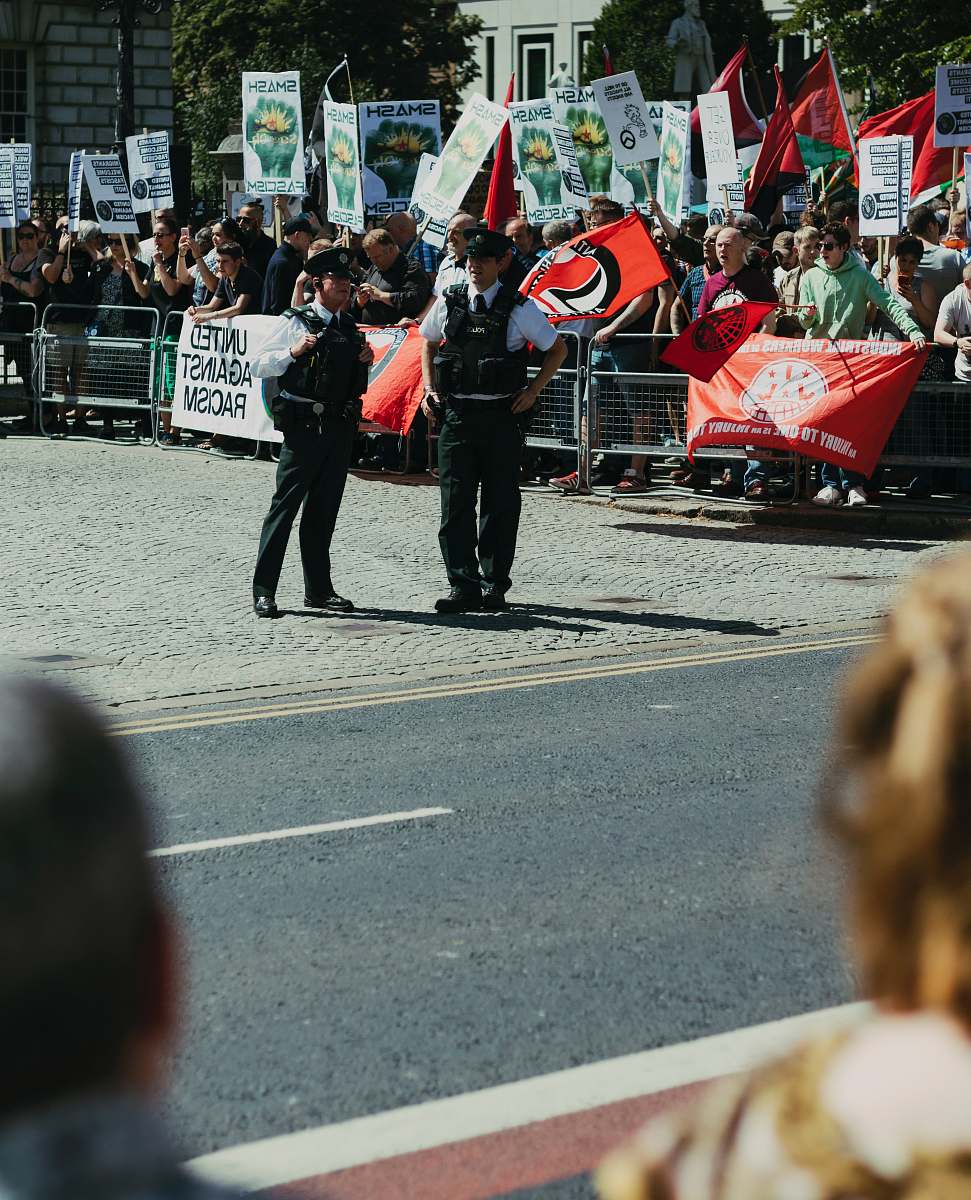 human two policemen standing beside group of people person