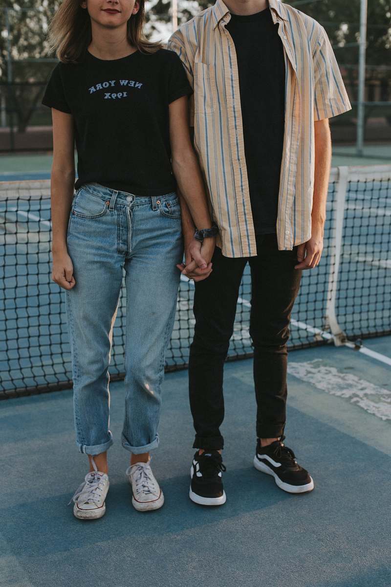 human woman and man standing side by side while holding hands in tennis court person