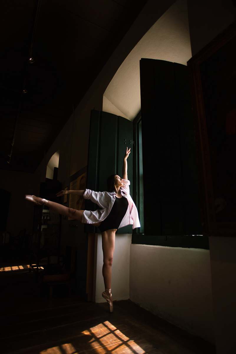 person woman doing ballet pose in front of window during daytime dance