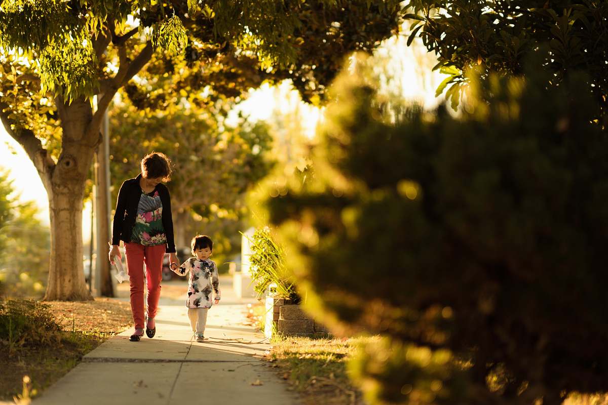 person woman holding a child walking in the pathway human