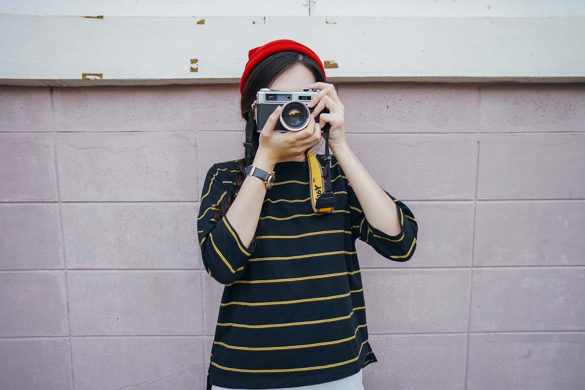human woman holding DSLR camera while taking picture person