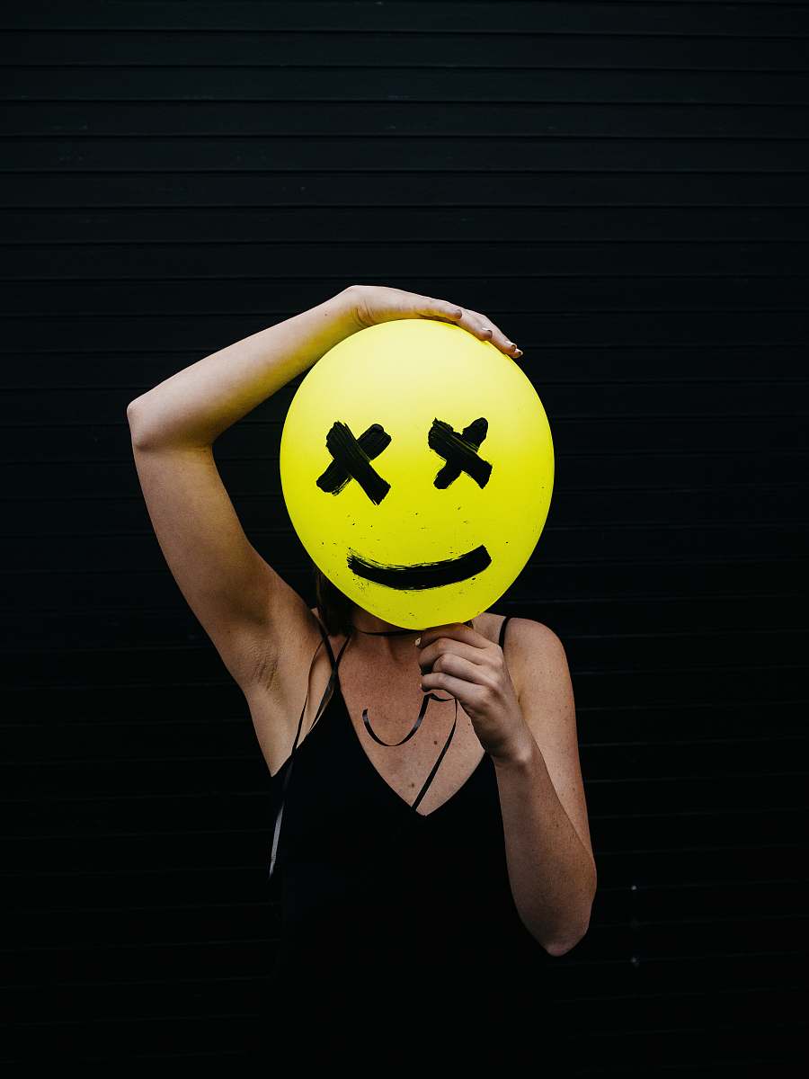 human woman holding yellow and black balloon at daytime person