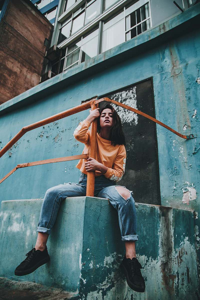 human woman hugging post of orange metal railings during day person