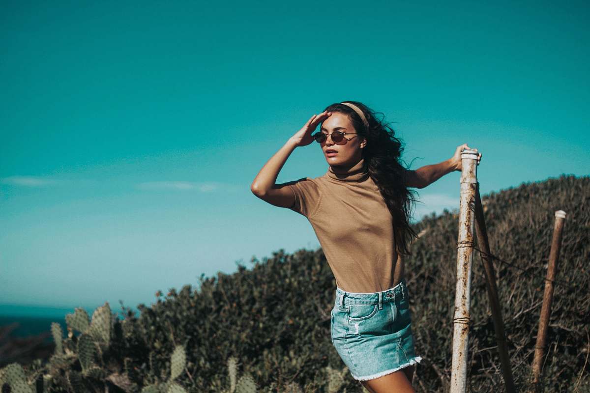 human woman in brown turtle-neck T-shirt holding brown bamboo stick person