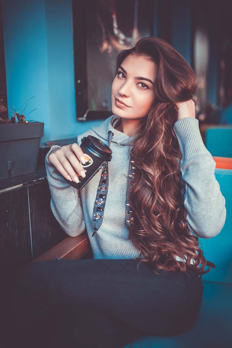 human woman in gray pullover hoodie sitting on sofa person