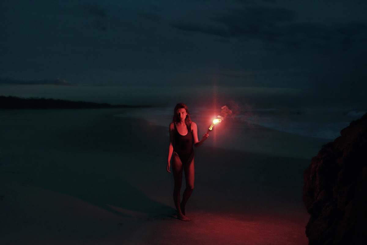 human woman in one-piece swimsuit holding torch person