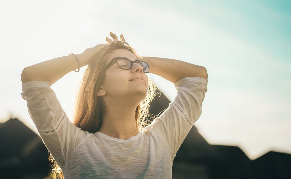 human woman in white crew-neck T-shirt holding her head person