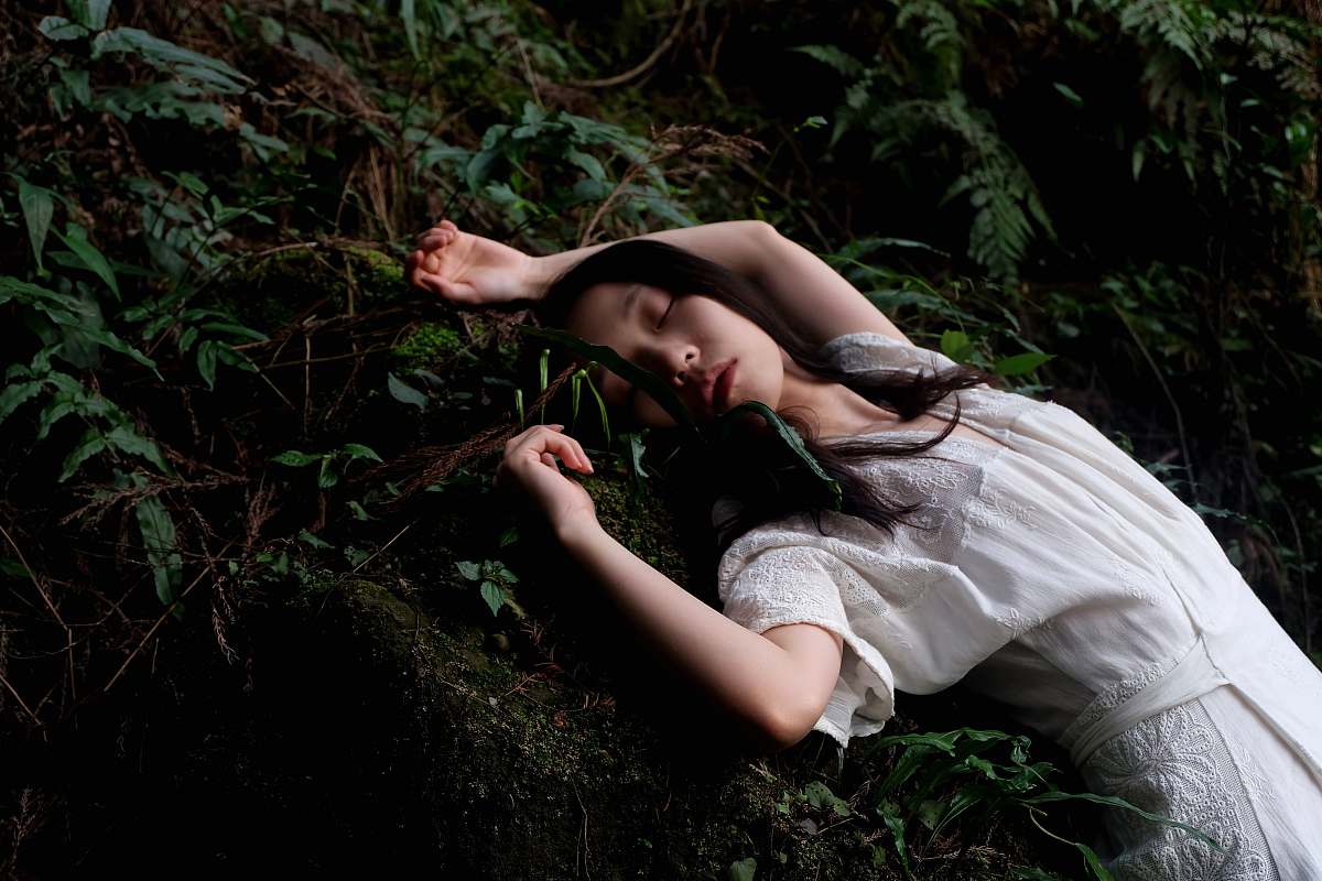 woman woman in white dress lying in white dress forest