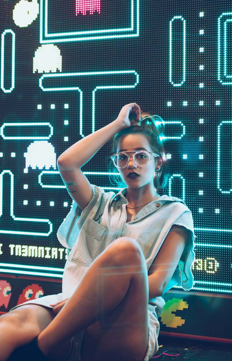 person woman leaning against monitor displaying Pacman game human