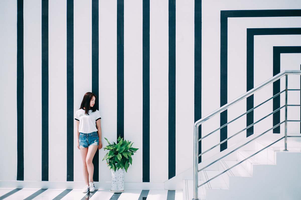 human woman leaning on black and white wall person