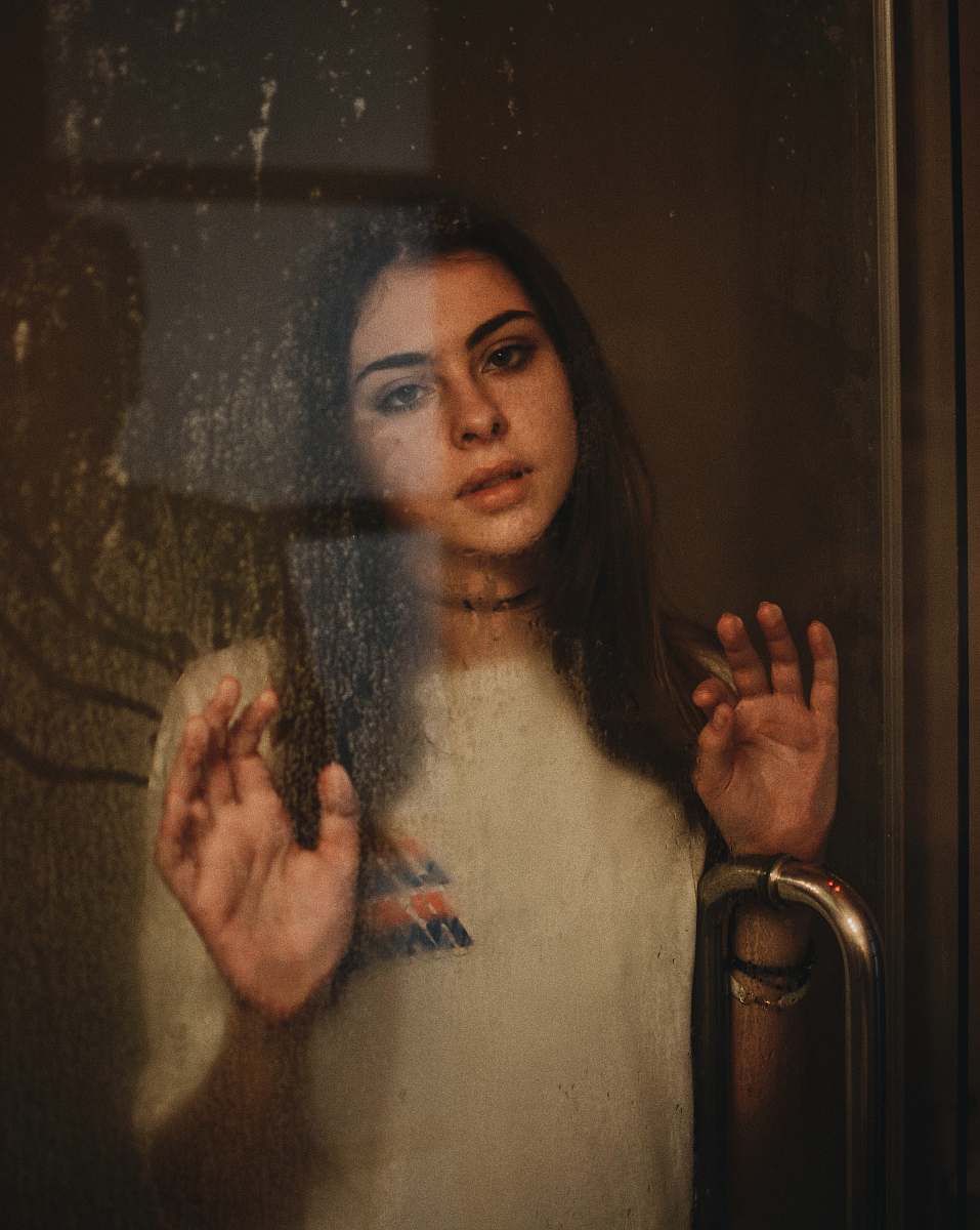 person woman leaning on glass door human
