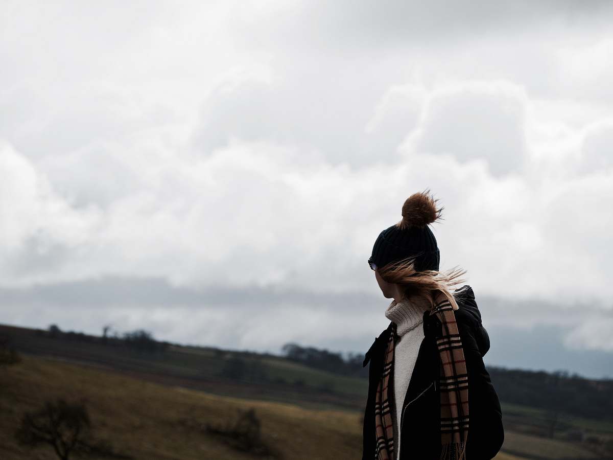 person woman looking at back under nimbus clouds human