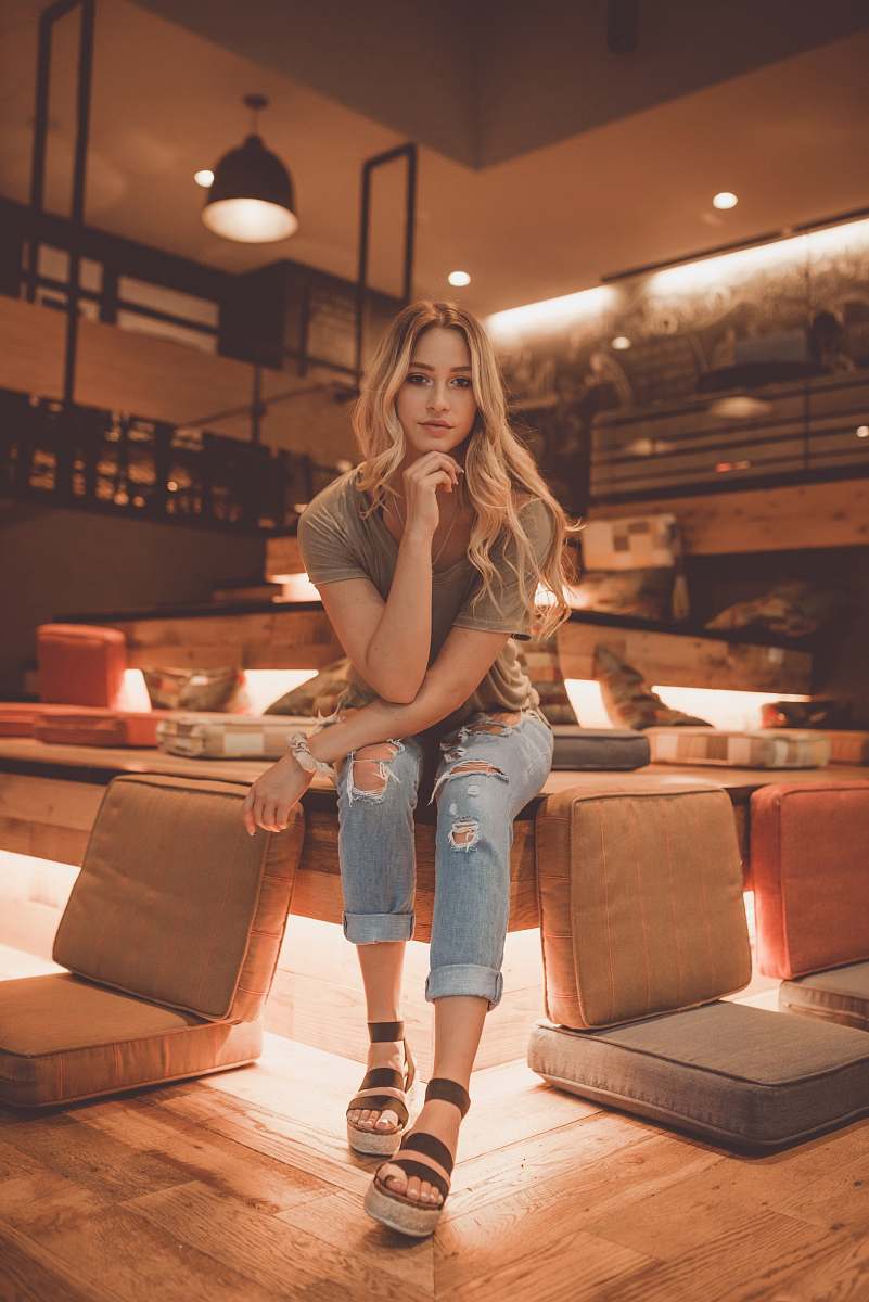 person woman sitting between brown chairs couch