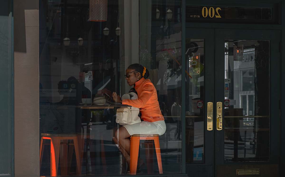 person woman sitting in front of brown table door