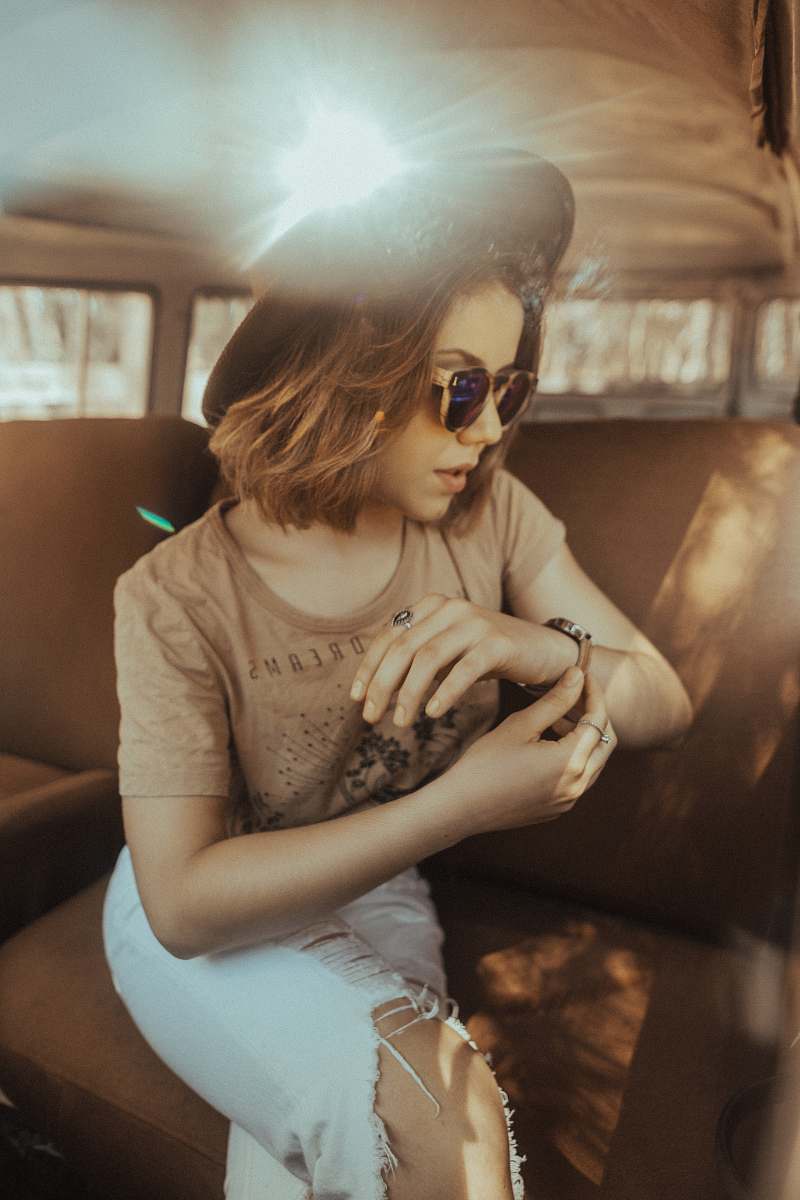 person woman sitting on car seat while looking at her watch human