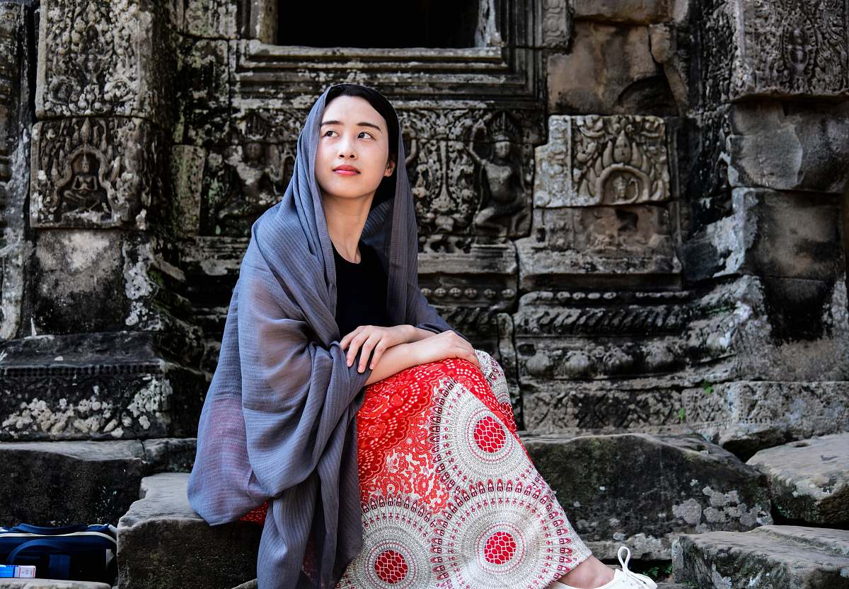 human woman sitting on concrete stone person