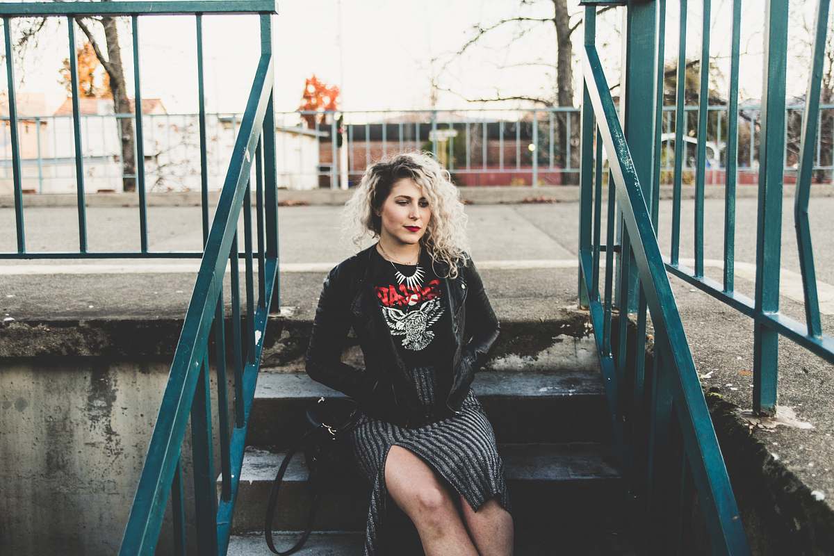 person woman sitting on gray concrete stairs railing