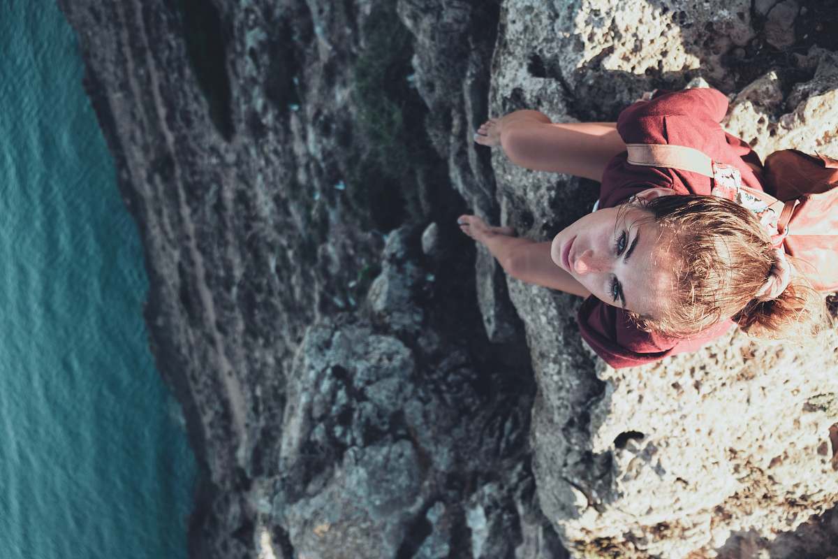 human woman sitting on mountain cliff person