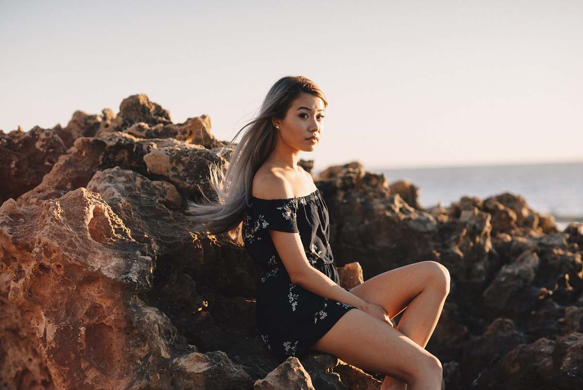 human woman sitting on rock person