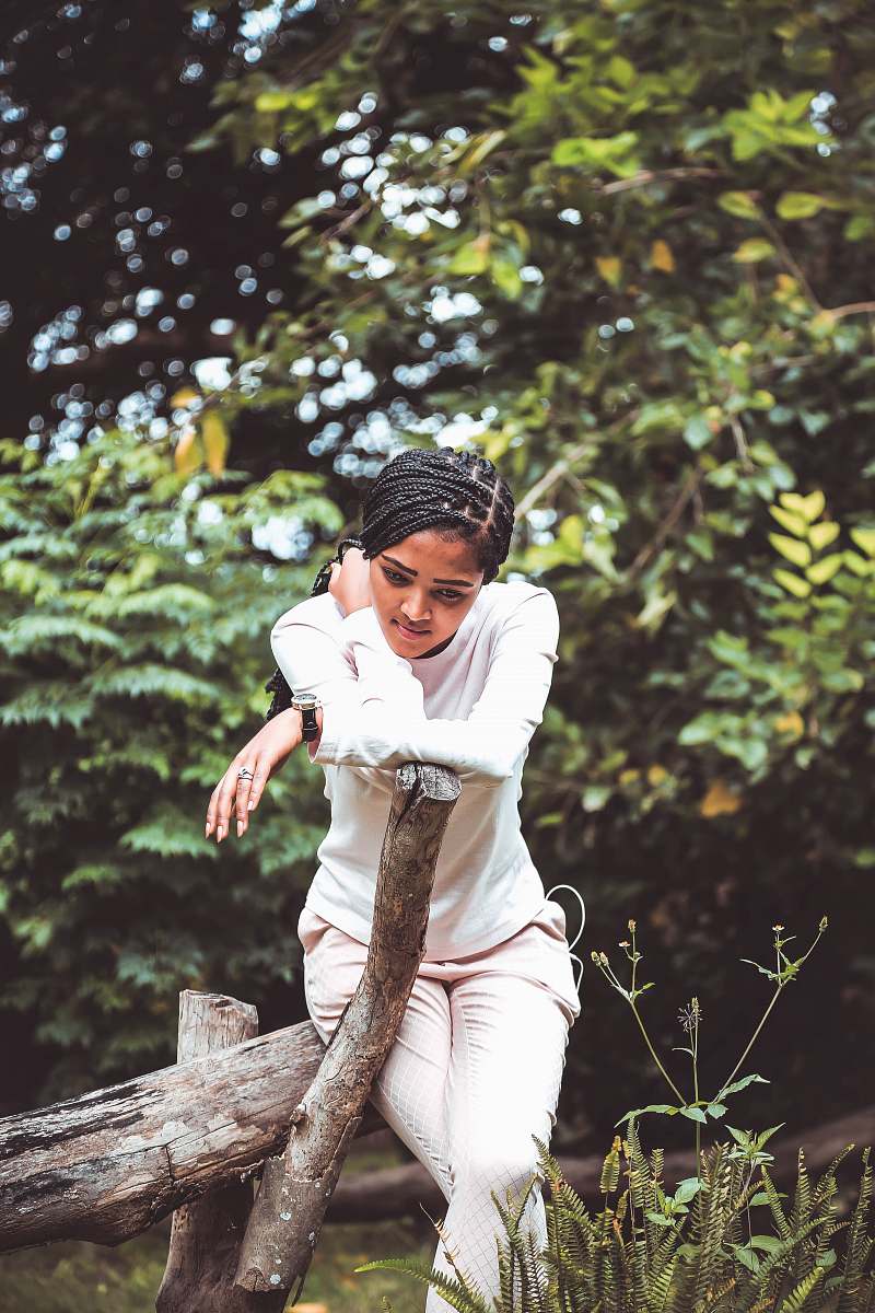 human woman sitting on tree log during daytime person