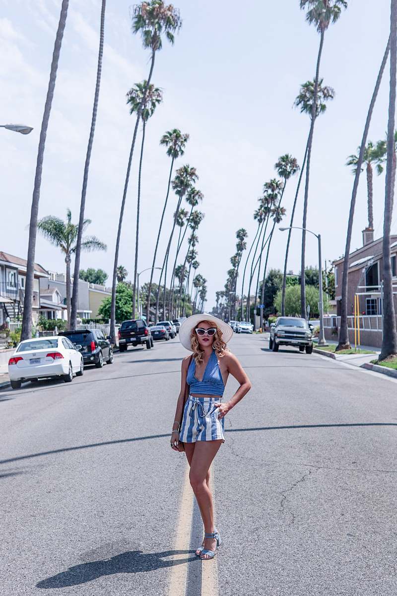 human woman standing in the middle of road between trees person