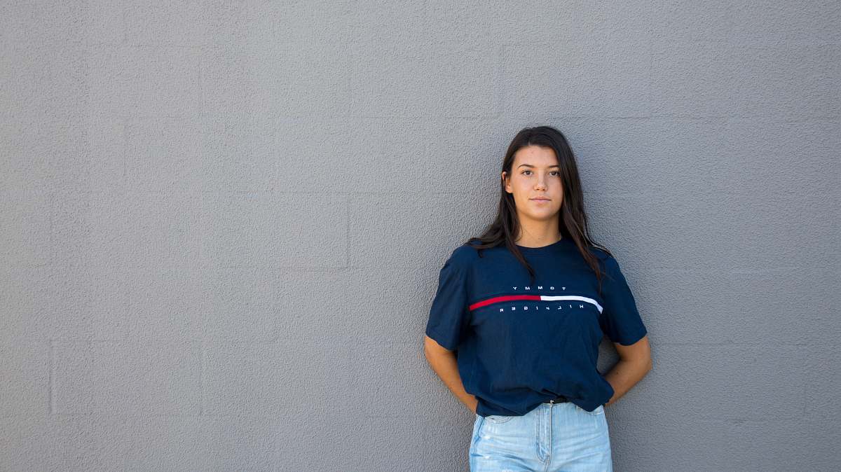 person woman standing while leaning on wall human