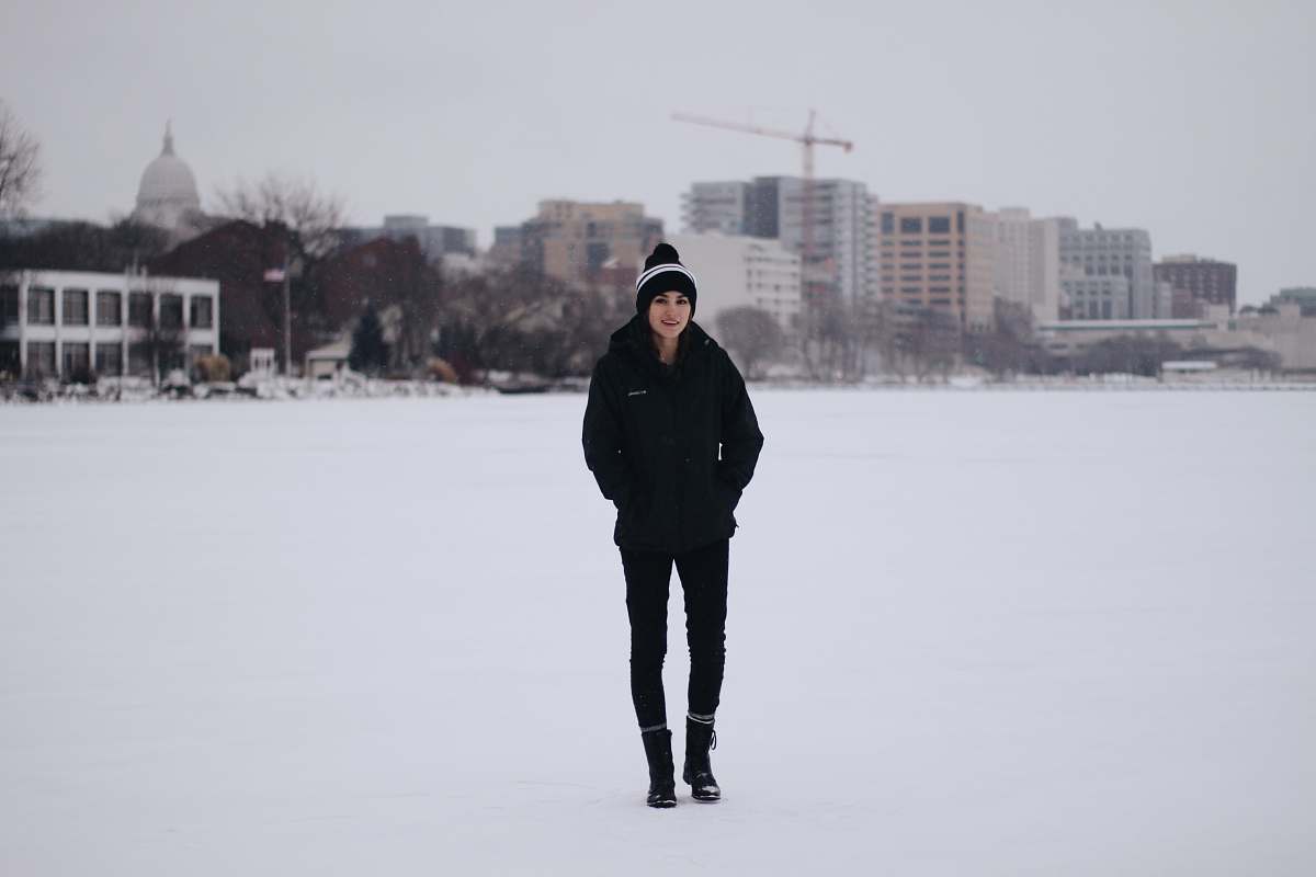 human woman walking on field with snow and bulidings person